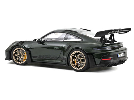 Dark green sports car with gold rims.