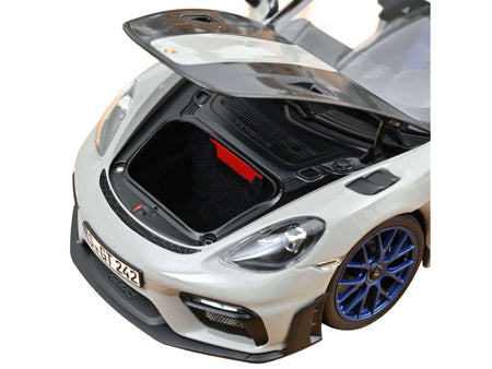 White sports car with open hood.