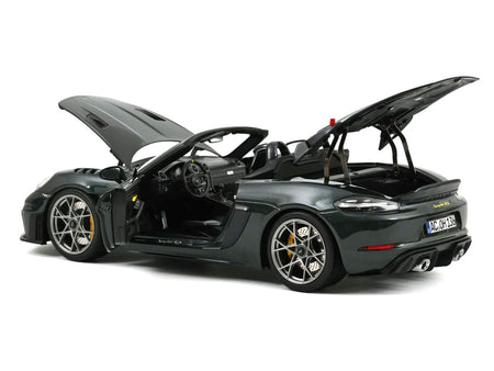 Dark green convertible car with open hood and trunk.