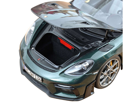 Green sports car with open hood.