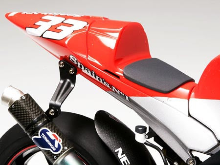 Red and white motorcycle tail with number 33 and exhaust pipe.