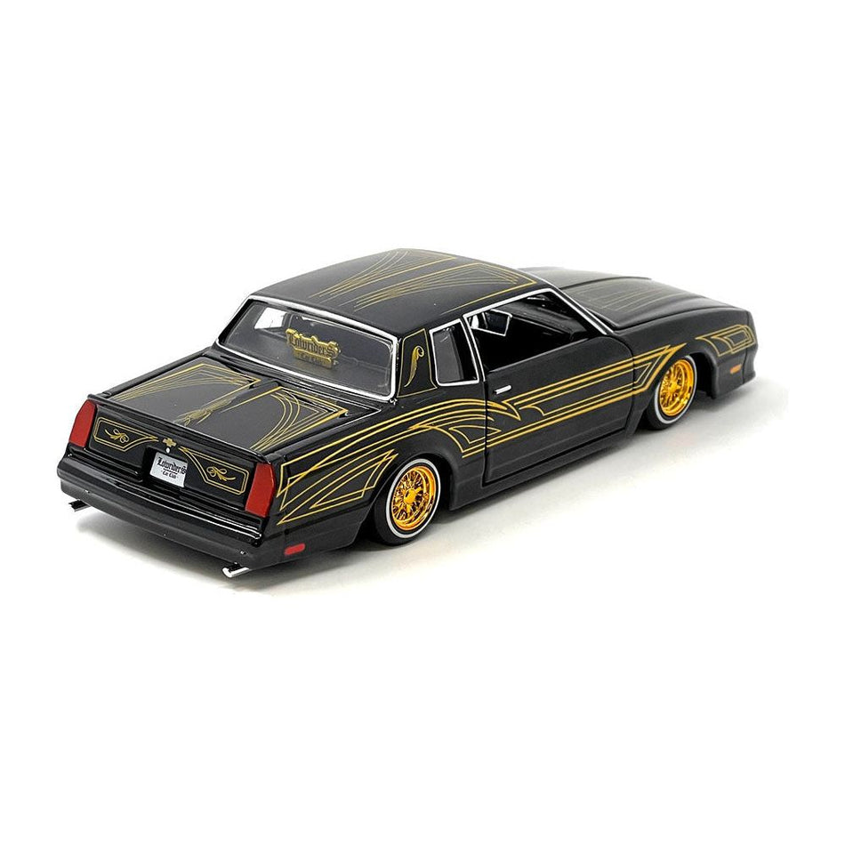 1986 Chevrolet Monte Carlo SS Lowrider Black Metallic with Gold Graphics and Wheels "Lowriders" Series 1/24 Diecast Model Car by Maisto