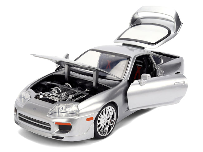 Silver toy car with open doors and hood.