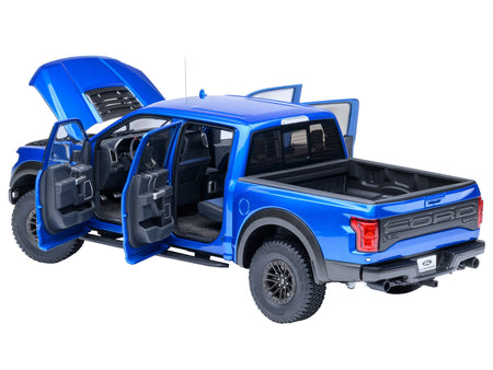 Blue Ford Raptor truck with doors and hood open.